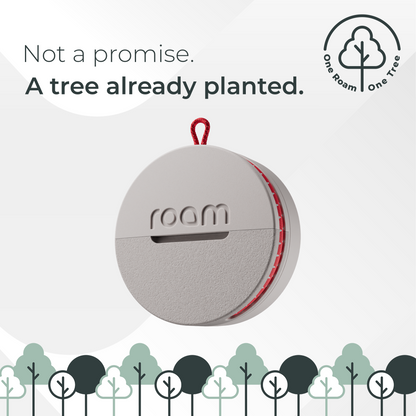 Round gray device with red accents and 'room' branding on a light gray background with tree illustrations.